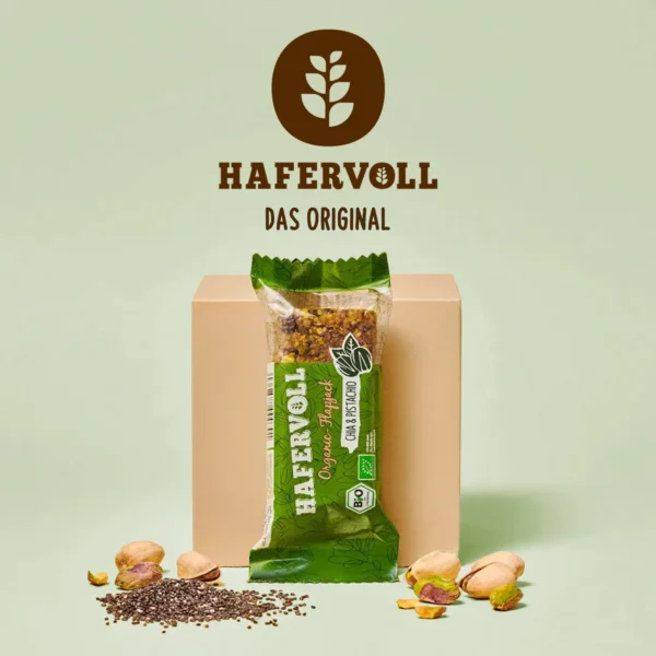 HAFERVOLL Organic Flapjack Chia & Pistachio 60g – Riegel in der Hand mit HAFERVOLL-Logo