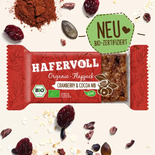 HAFERVOLL Organic Flapjack Cranberry & Cocoa Nib 60g – Riegel in der Verpackung mit Cranberrys und Kakaonibs