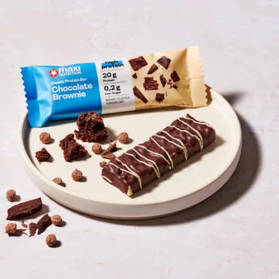 MaxiNutrition Classic Protein Bar Chocolate Brownie 40g – ausgepackt auf Teller mit Brownie-Stücken angerichtet